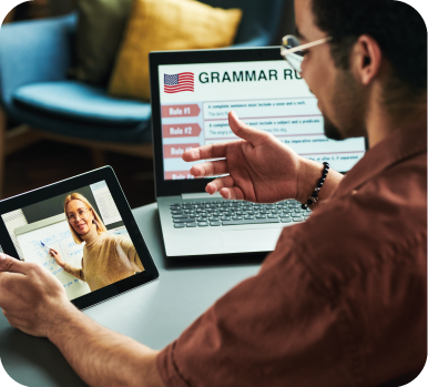 Uma pessoa em aula por um tablet com um notebook com elementos gráficos ao lado.